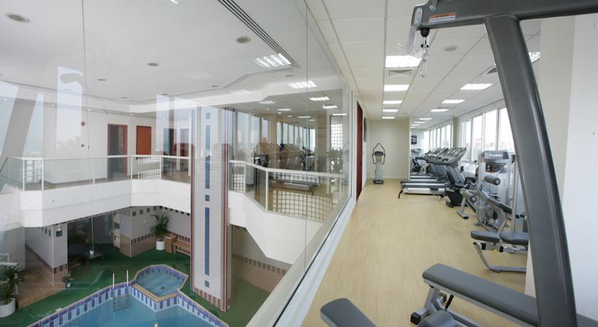 Тренажерный зал с видом на крытый бассейн