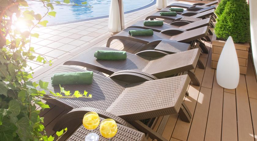 Шезлонги и полотенца под навесами у бассейна